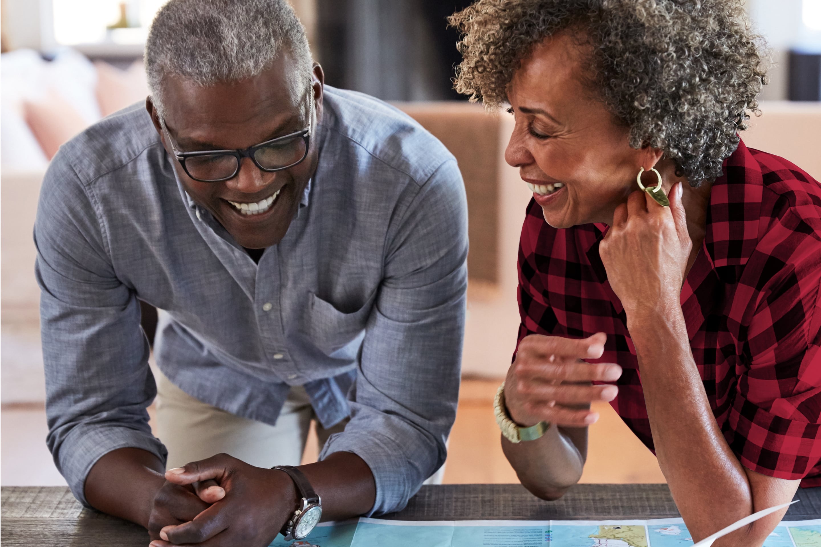 Two smiling people looking at a map.