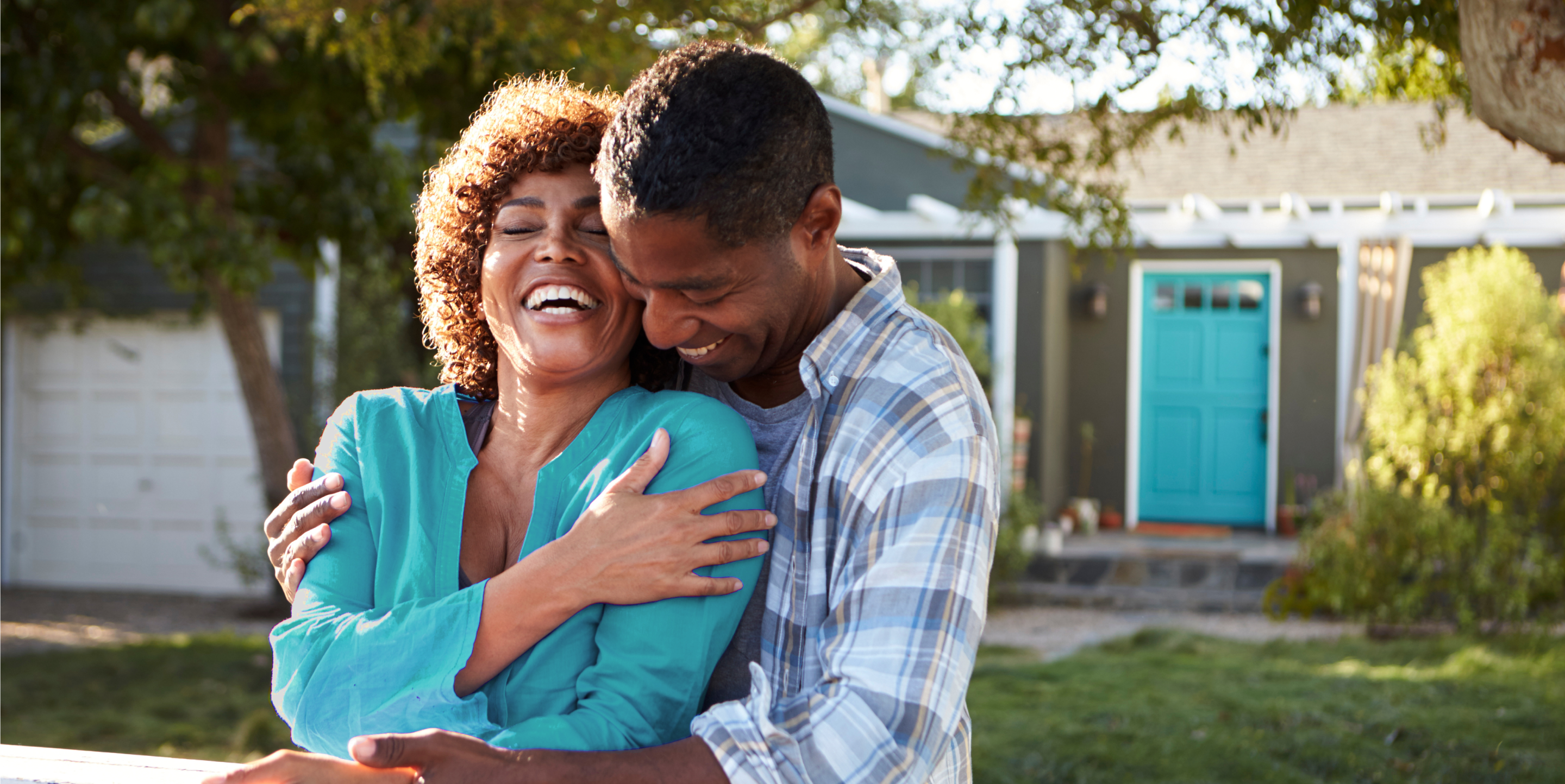 Couple hugs outside of house