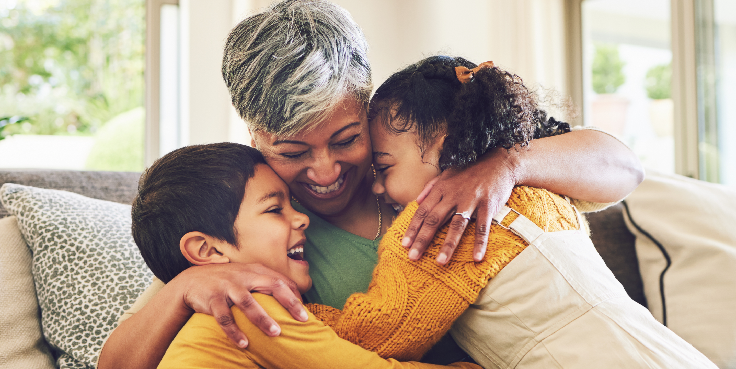 Smiling caregiver hugging children