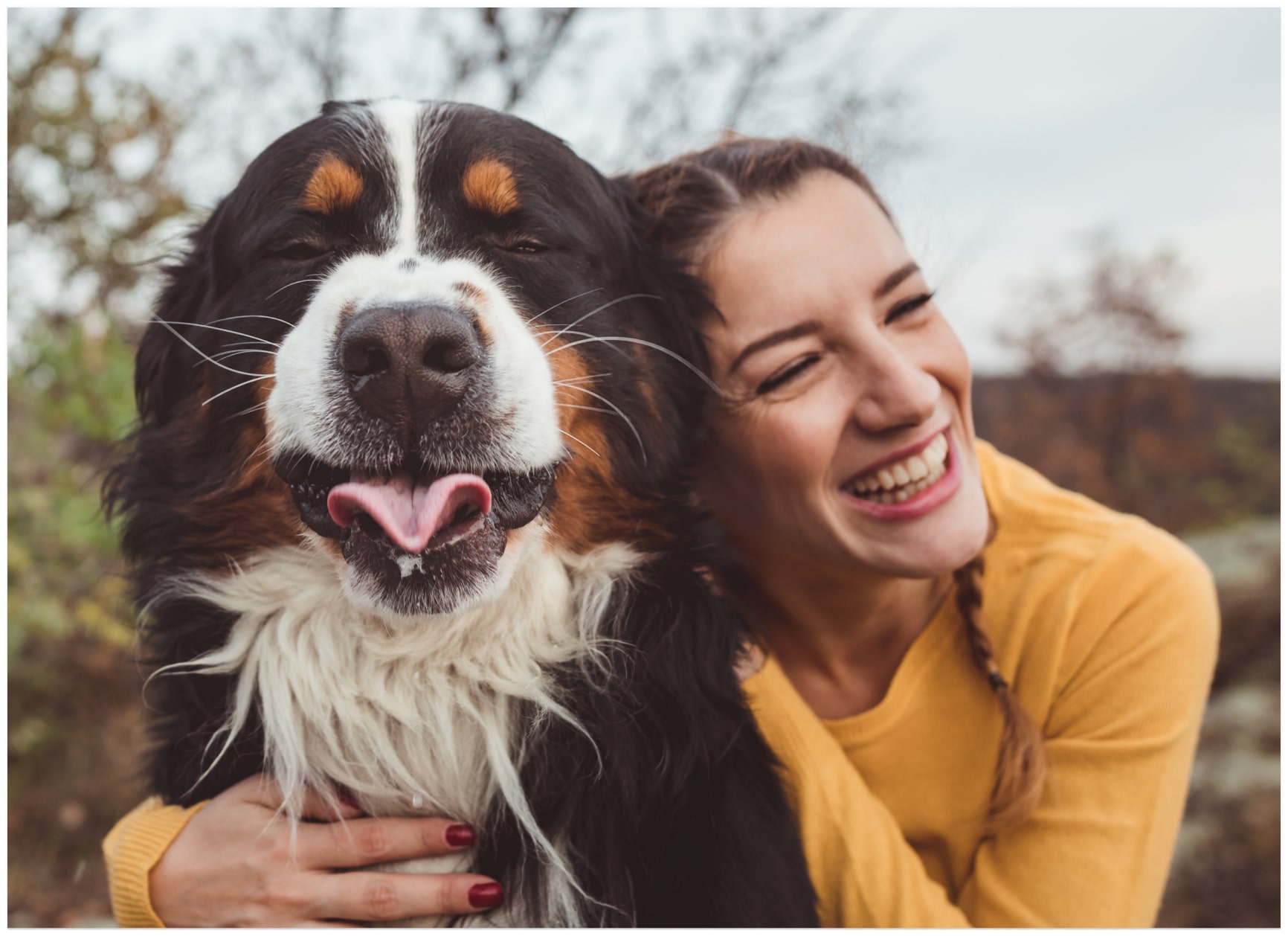 Smiling person hugging a big, happy dog.