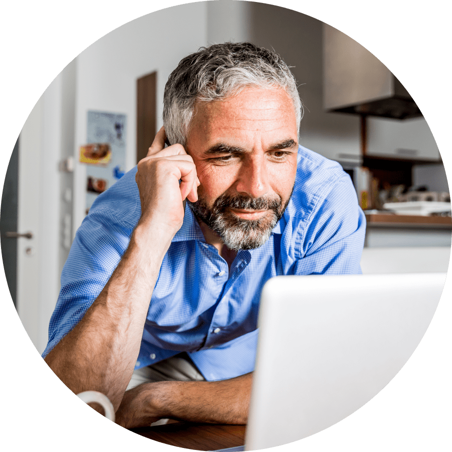 Person looking at a laptop in a kitchen